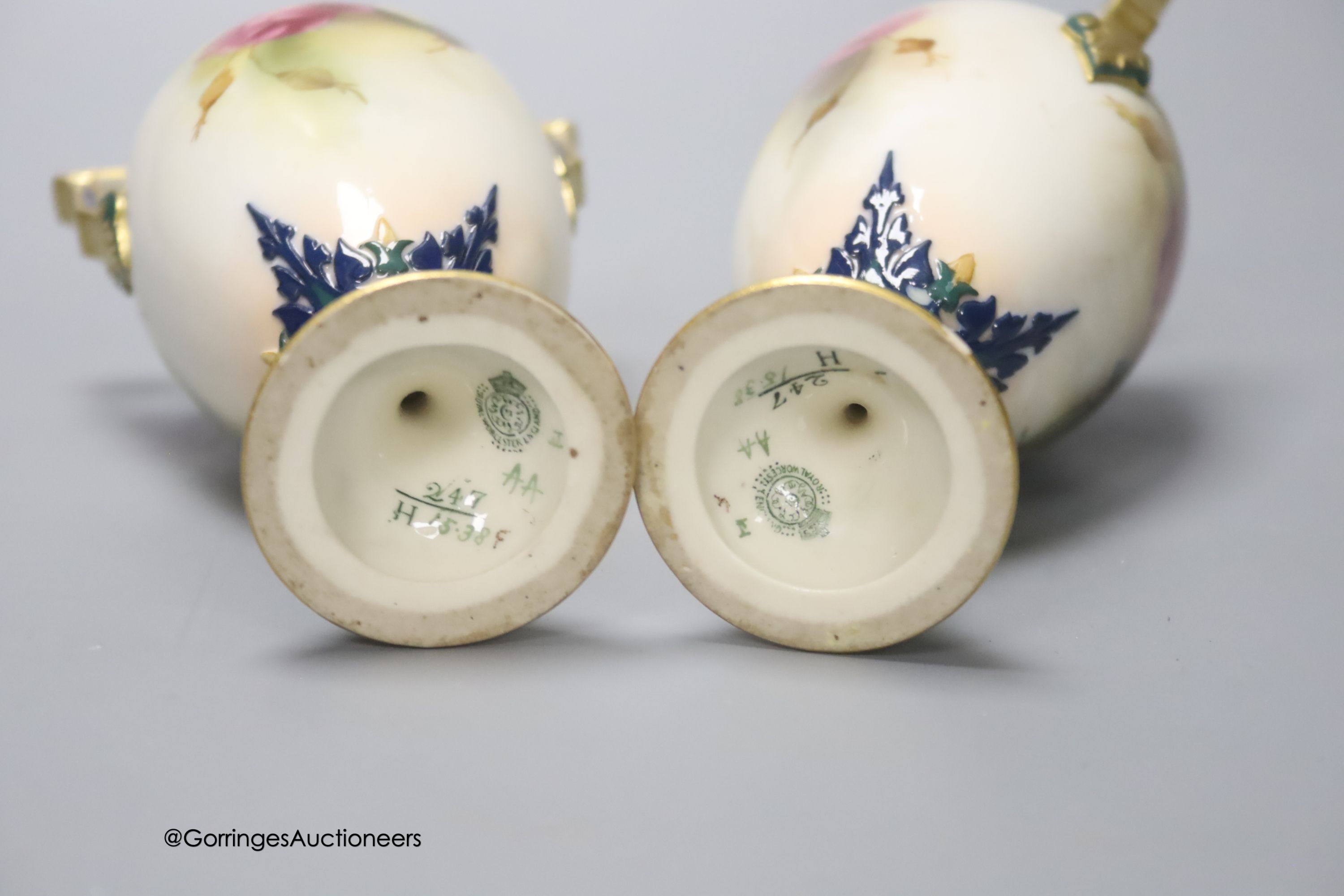 A pair of Royal Worcester two handled vases, decorated with roses, unsigned, 18cm (one a.f.)